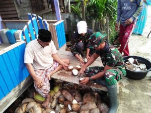Bagai Satu Keluarga, Anggota Satgas Ini Ikut Bantu Kupas Kelapa Warga