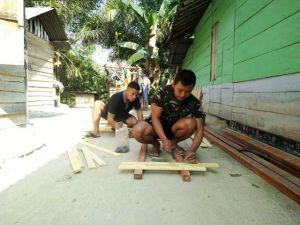 Kopda Yogi Bersama Rekannya Siapkan Pagar untuk Rumah Orang Tua Asuh