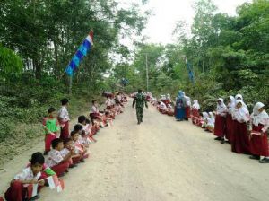 Bawa Bendera, Ratusan Siswa SD Sambut Tamu Undangan di Upacara Penutupan TMMD di Desa Ladang Peris