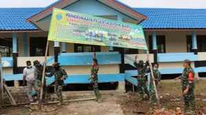 Satgas TMMD Bantu Perbaiki Pemasangan Spanduk Penerimaan Siswa di SMPN Satu Atap 9 Labuhan Pering