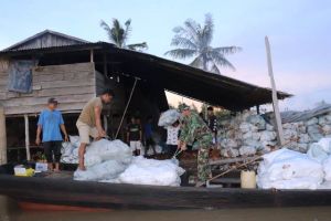 Kepedulian Anggota Satgas TMMD di Desa Labuhan Pering Bantu Warga Muat Kelapa ke Pompong