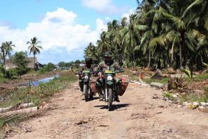 Anggota Satgas TMMD Bagikan Sembako Gunakan Sepeda Motor di Desa Labuhan Pering