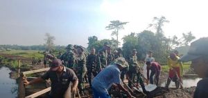 Kompak.. Warga dan Satgas TMMD Gotong Royong Ratakan Jalan di Jembatan