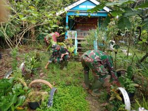 Satgas TMMD Bantu Ibu-Ibu Bersihkan Taman PKK Desa Mekar Jaya