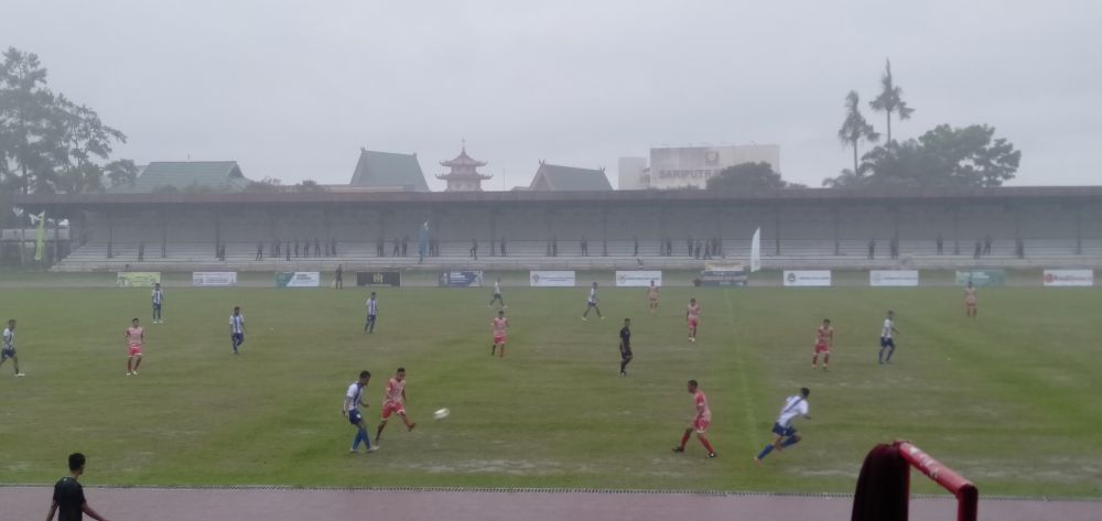 Suasana pertandingan diguyur hujan, Tebo (biru putih), Tanjabtim (merah).