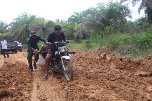 Babinsa Bantu Warga Dorong Motor yang Terperosok di Jalan Baru TMMD