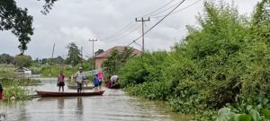 Akses Menuju TPS Banjir, Sejumlah Warga Gunakan Perahu demi Nyoblos